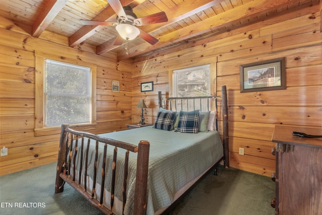 bedroom featuring ceiling fan, wooden ceiling, beamed ceiling, wooden walls, and dark carpet