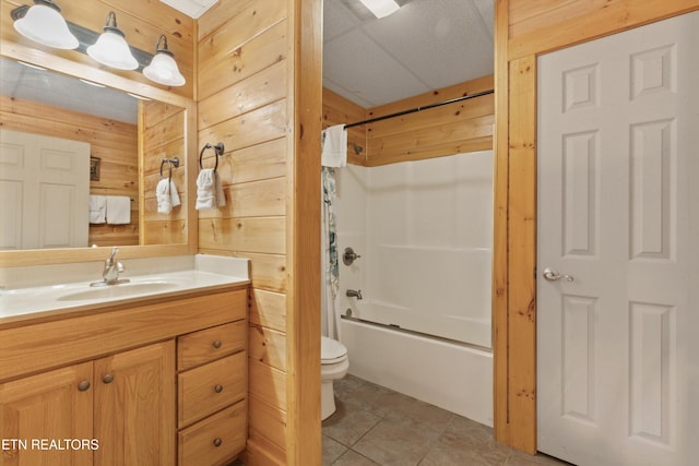 full bathroom featuring shower / bathtub combination with curtain, tile patterned flooring, toilet, wooden walls, and vanity