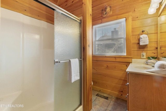 bathroom featuring wood walls, tile patterned flooring, vanity, and walk in shower