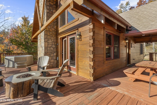 wooden terrace featuring a fire pit and a jacuzzi