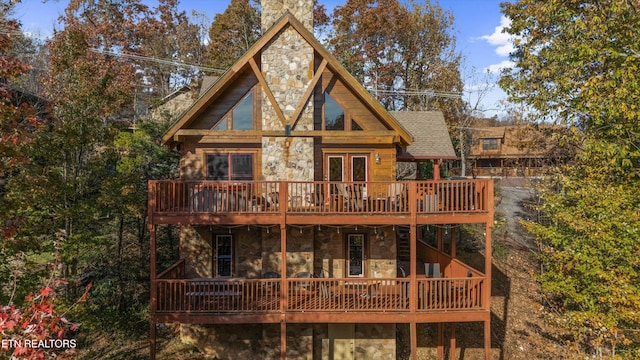 rear view of house featuring a wooden deck