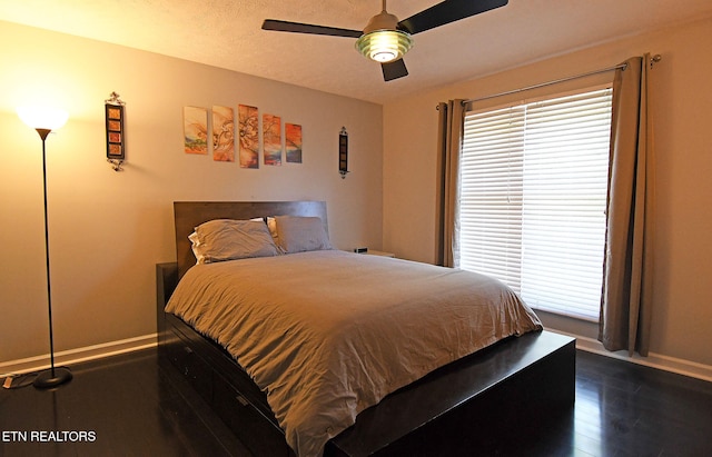 bedroom with ceiling fan and dark hardwood / wood-style floors