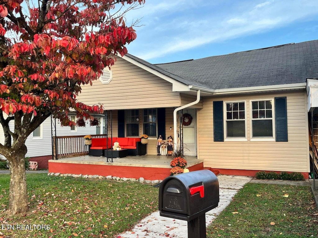 view of front of property featuring covered porch and a front yard