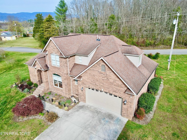 view of front of house featuring a mountain view, a front lawn, and a garage