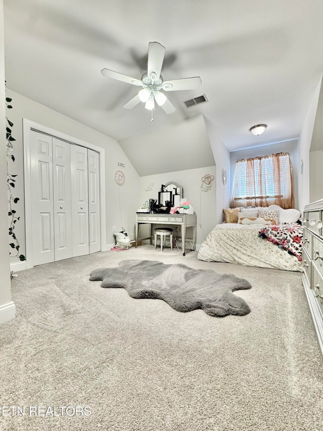 bedroom featuring carpet, ceiling fan, a closet, and vaulted ceiling