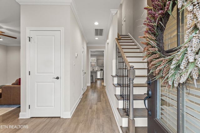 foyer featuring ceiling fan, light hardwood / wood-style floors, and crown molding