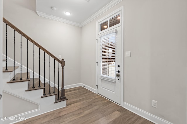 entryway with hardwood / wood-style floors and ornamental molding