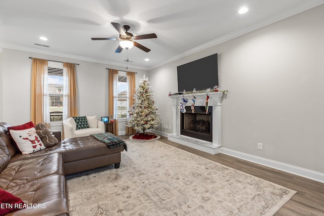 living room with crown molding, ceiling fan, and wood-type flooring