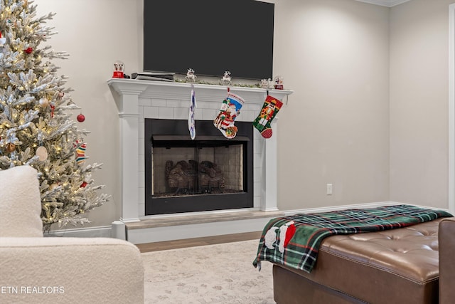 bedroom featuring a tiled fireplace and hardwood / wood-style flooring