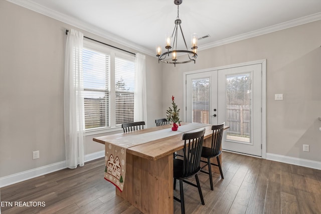 dining area featuring french doors, dark hardwood / wood-style floors, an inviting chandelier, and ornamental molding