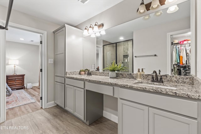 bathroom with a shower with door, vanity, and hardwood / wood-style flooring