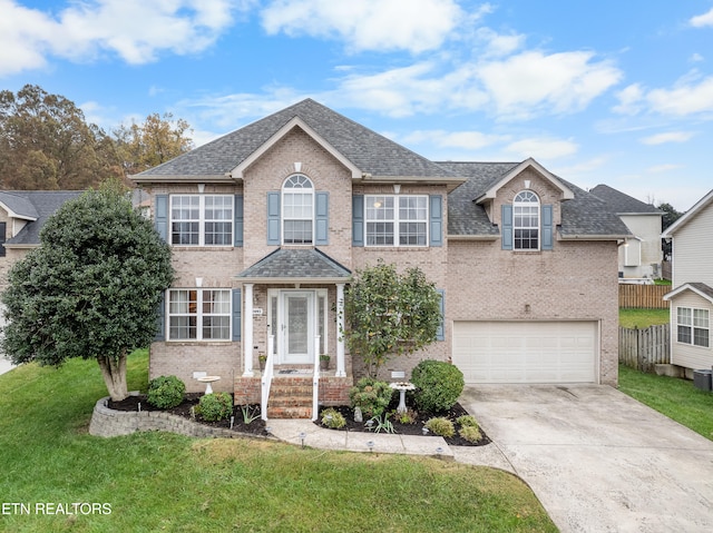 view of front of property featuring a garage and a front lawn