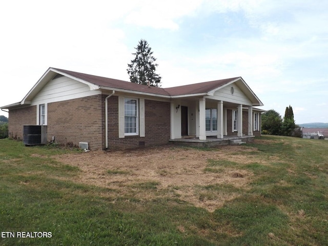 view of front of house featuring a front yard, covered porch, and brick siding