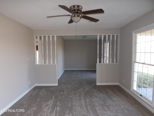 carpeted spare room featuring baseboards, a healthy amount of sunlight, and a ceiling fan