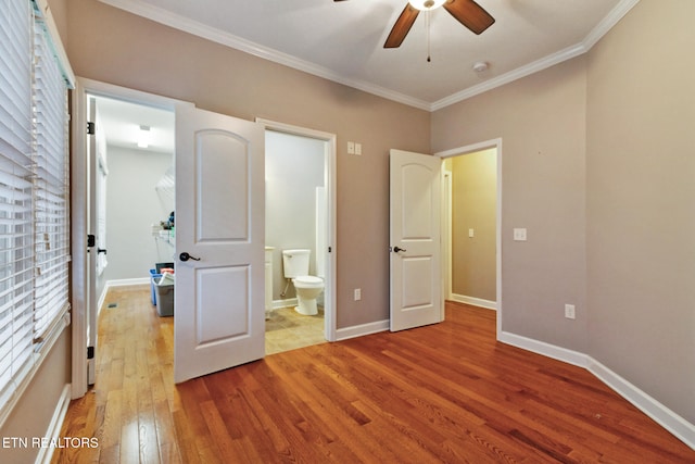 unfurnished bedroom featuring ceiling fan, ensuite bathroom, light wood-type flooring, and crown molding