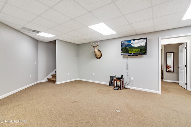 basement featuring carpet flooring and a paneled ceiling