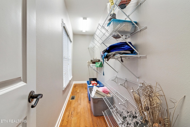 walk in closet with wood-type flooring