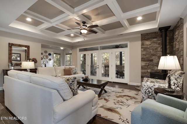 living room with coffered ceiling, ornamental molding, and a wood stove