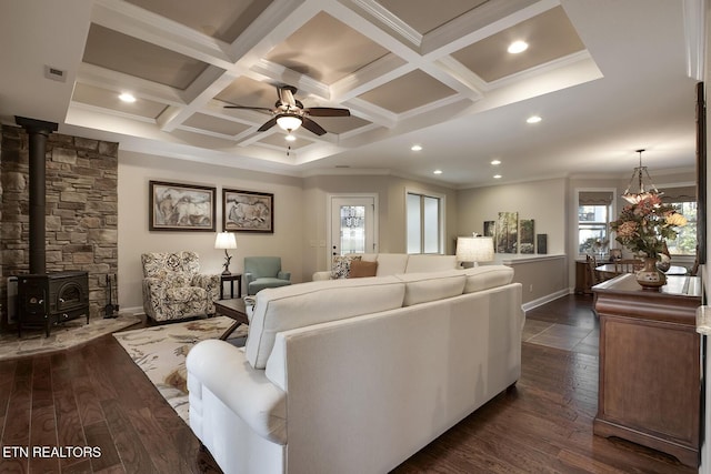 living room with coffered ceiling, a wood stove, dark hardwood / wood-style floors, beamed ceiling, and ceiling fan