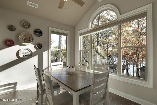 tiled dining room with ceiling fan and vaulted ceiling