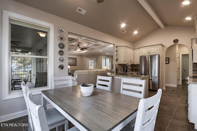 tiled dining space with beamed ceiling, ceiling fan, and sink