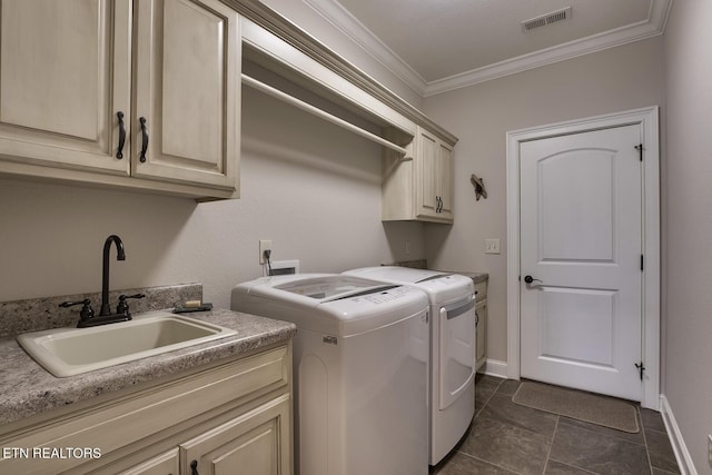 washroom with sink, cabinets, separate washer and dryer, ornamental molding, and dark tile patterned flooring