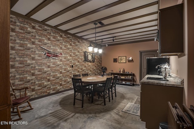 dining room with beamed ceiling, brick wall, and sink