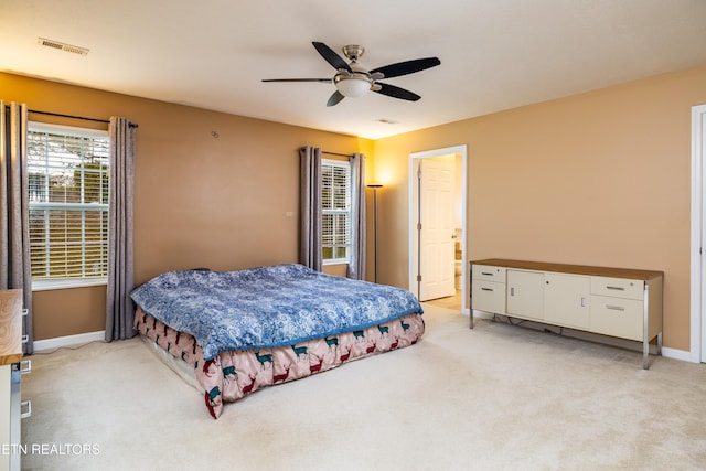 carpeted bedroom featuring ceiling fan and ensuite bathroom