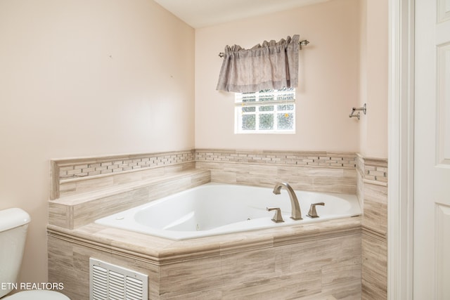 bathroom with a relaxing tiled tub and toilet