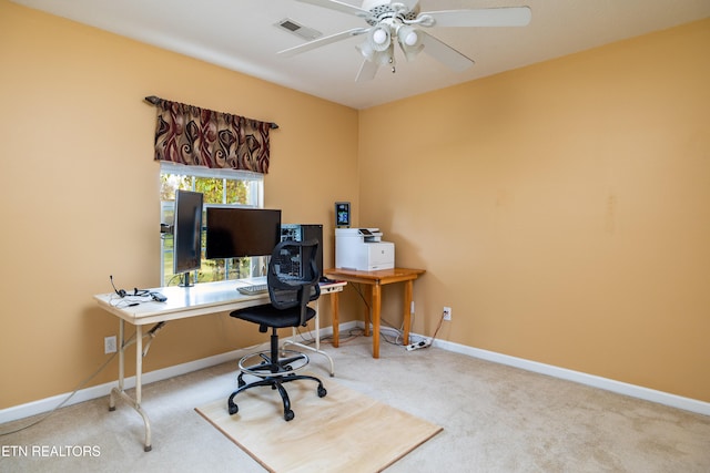 carpeted office space featuring ceiling fan