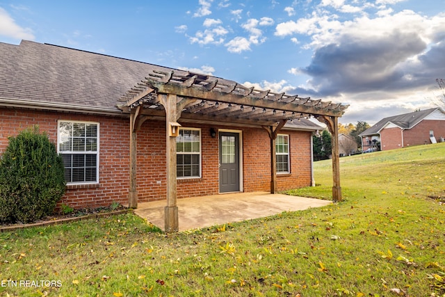 rear view of house with a pergola, a patio area, and a lawn