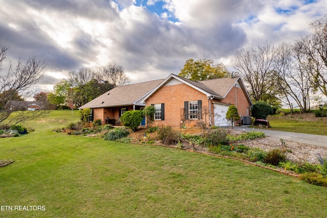 view of front of house with central AC, a front lawn, and a garage