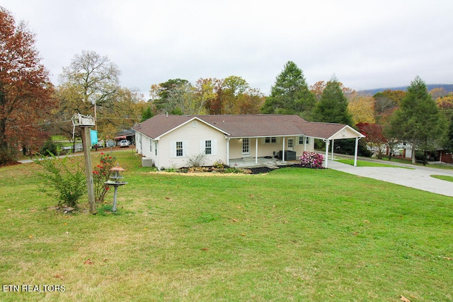 ranch-style home with a front yard, a carport, and covered porch