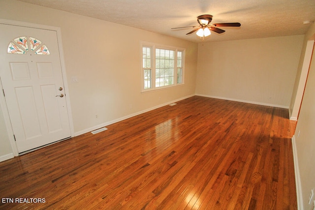 foyer with a textured ceiling, ceiling fan, and dark hardwood / wood-style floors