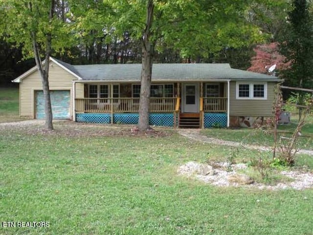 ranch-style house with covered porch, a garage, and a front lawn