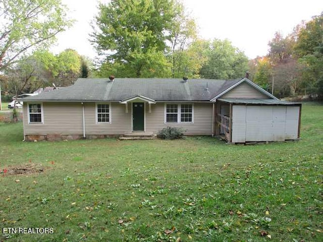 rear view of property featuring a lawn