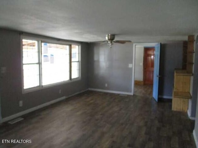 unfurnished living room with dark hardwood / wood-style floors and ceiling fan