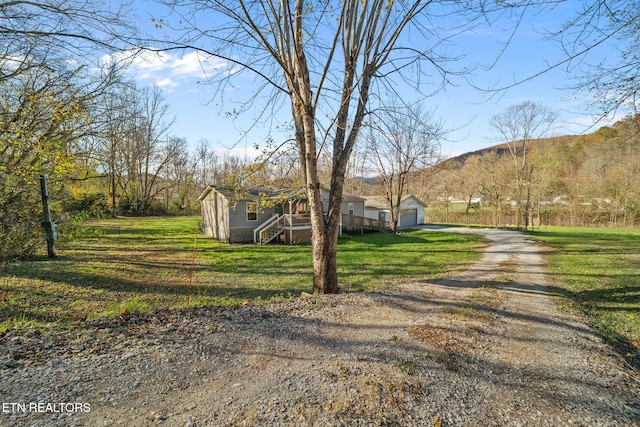 view of front of property with a mountain view, a garage, and a front lawn