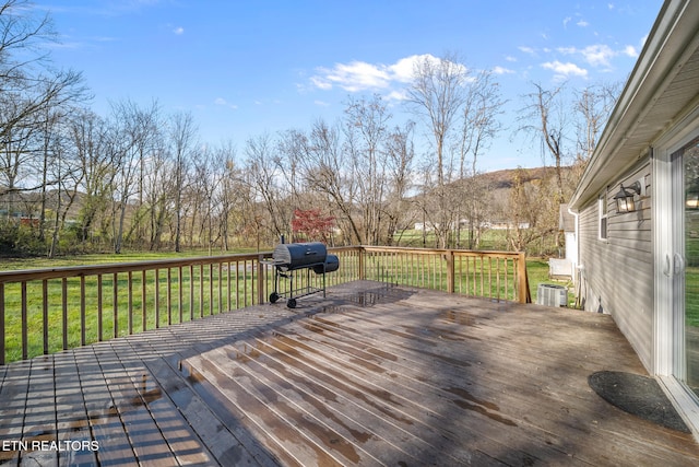 wooden deck featuring a grill and a yard