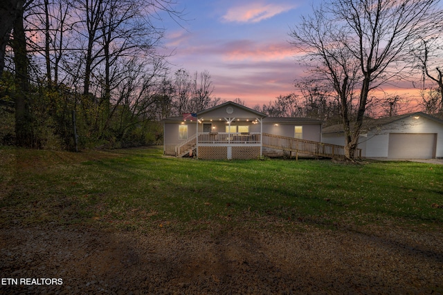 yard at dusk featuring a porch and a garage