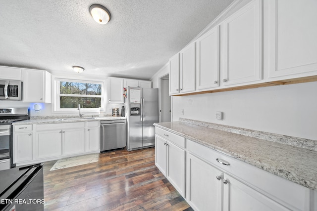 kitchen featuring sink, dark hardwood / wood-style floors, a textured ceiling, appliances with stainless steel finishes, and white cabinetry