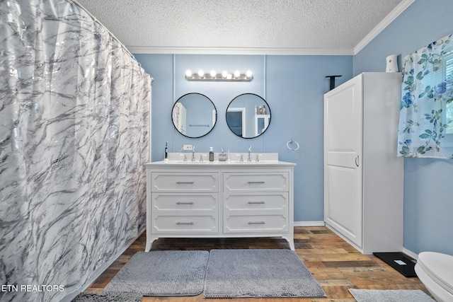 bathroom featuring vanity, a textured ceiling, hardwood / wood-style flooring, and crown molding