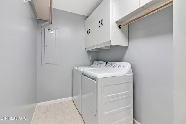 washroom with cabinets, electric panel, and washer and dryer