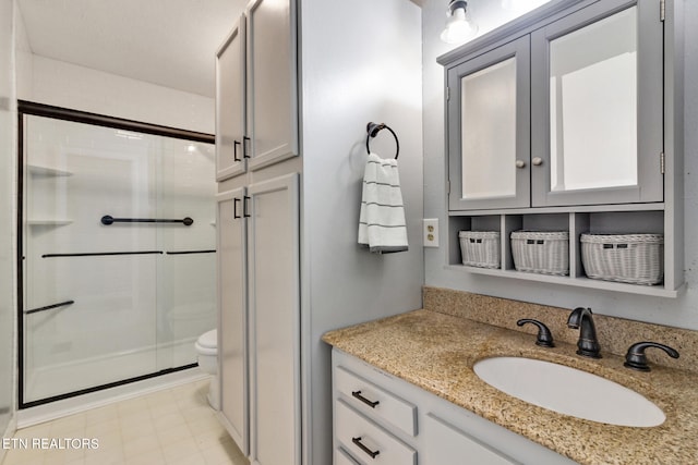 bathroom with vanity, toilet, and a shower with shower door