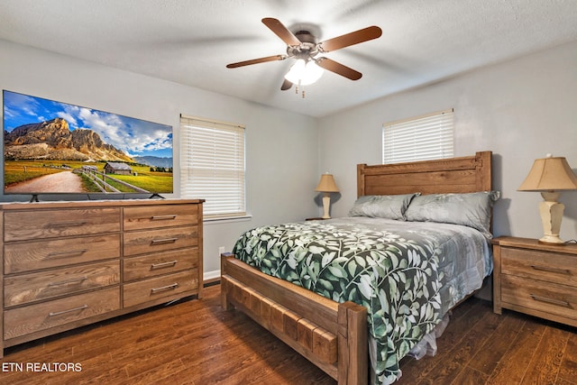 bedroom with multiple windows, ceiling fan, and dark wood-type flooring