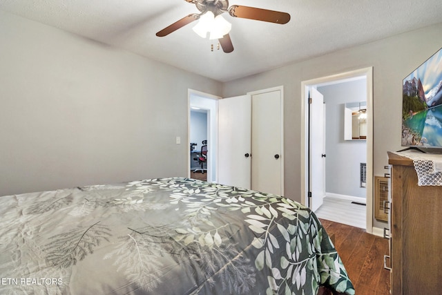 bedroom featuring connected bathroom, ceiling fan, dark hardwood / wood-style flooring, and a textured ceiling