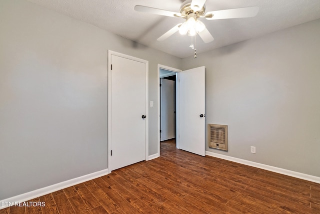 spare room with heating unit, ceiling fan, dark hardwood / wood-style flooring, and a textured ceiling