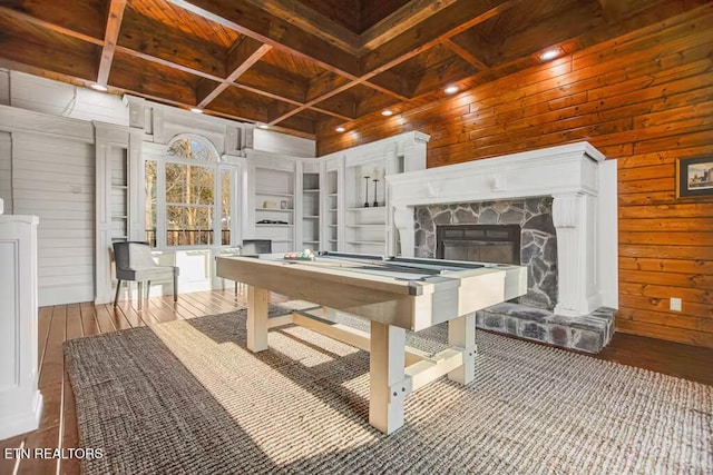 recreation room featuring coffered ceiling, wooden walls, billiards, light hardwood / wood-style floors, and a stone fireplace