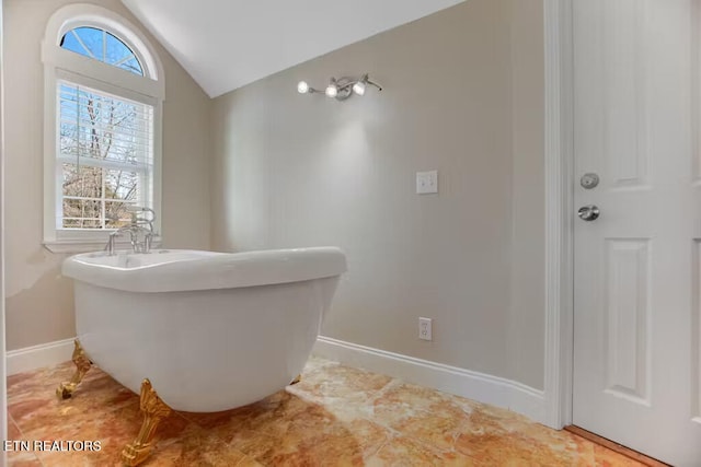 bathroom with a bathing tub and lofted ceiling