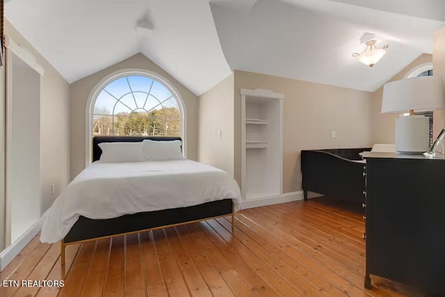 bedroom with hardwood / wood-style floors and lofted ceiling